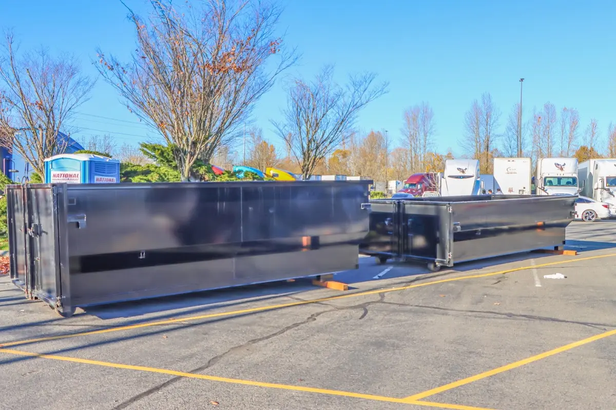 Professional dumpster rental service with roll-off container on residential driveway in Holtville